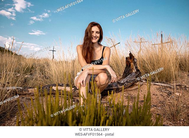 Portrait of smiling young woman sitting in the countyside