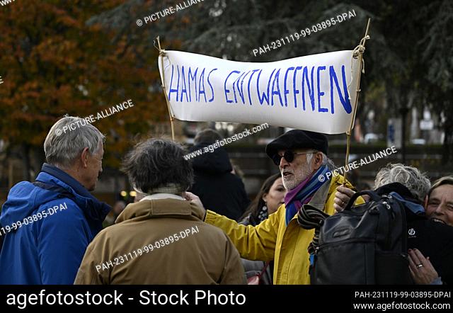19 November 2023, North Rhine-Westphalia, Cologne: A participant in a Jewish-Palestinian peace demonstration holds up a banner reading ""Unleash Hamas""