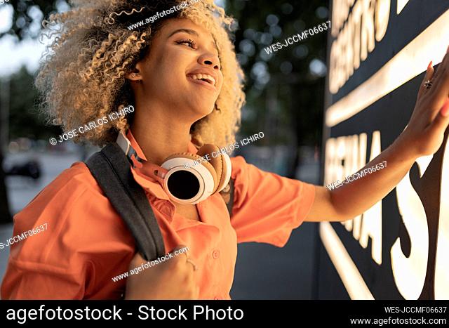 Happy young woman touching illuminated banner