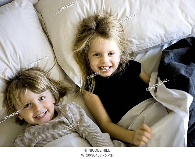 USA, Utah, Provo, Portrait of brother and sister 2-5 lying in bed