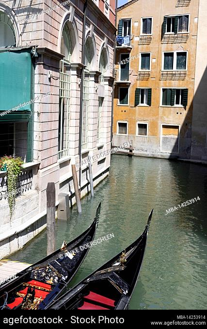 Two tops of Venetian gondolas on a canal in Venice, Italy