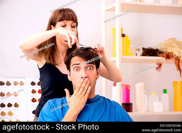 Young attracrive man visiting female barber
