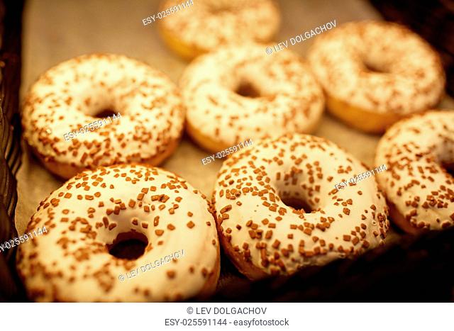 food, baking and sale concept - close up of donuts at bakery or grocery store
