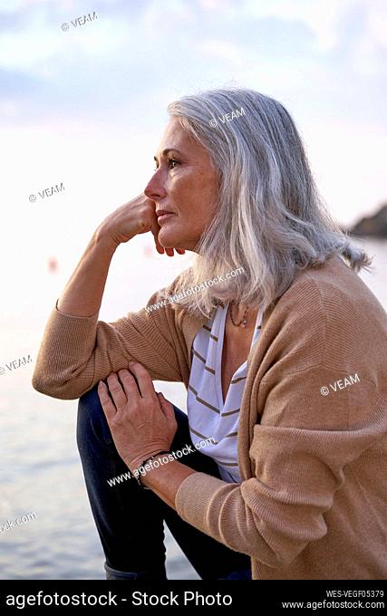 Thoughtful woman with gray hair at beach