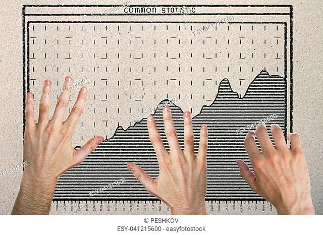 Abstract image of hands with drawn business chart on concrete background. Teamwork and economy concept