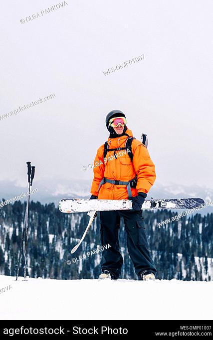 Man holding ski standing under clear sky