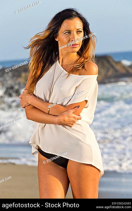 A beautiful brunette bikini enjoys the weather outdoors on a California Beach