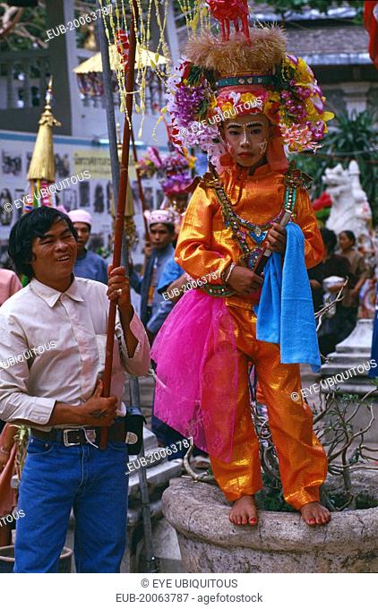 Shan Poi San Long. Crystal Children ceremony with Luk Kaeo in orange costume standing for photo at Wat Pa Pao