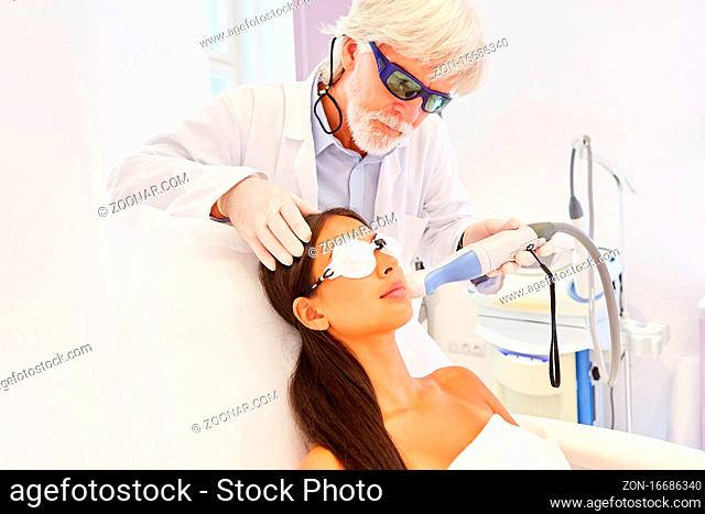 Hautarzt bei Hautverjüngung im Gesicht einer Patientin durch Laserbehandlung