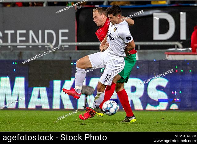 Oostende's Brecht Capon and Union's Dante Vanzeir fight for the ball during a soccer match between KV Oostende and Royale Union Saint-Gilloise