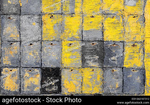 Close up abstract uneven grunge yellow and gray background with paint peeling off old weathered checkered wooden plywood surface