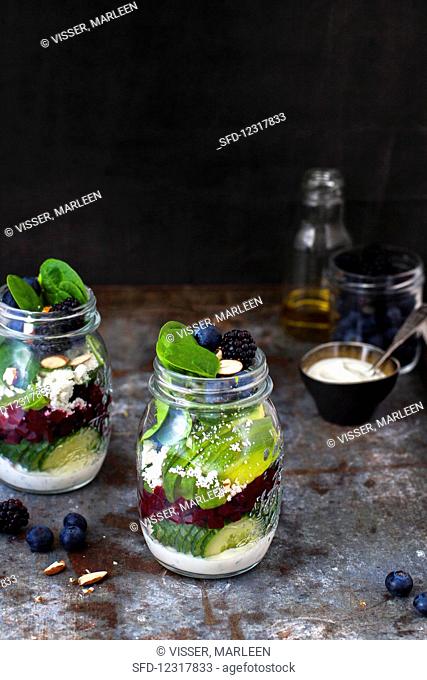 Vegetable salads with berries and yoghurt dressing in glass jars