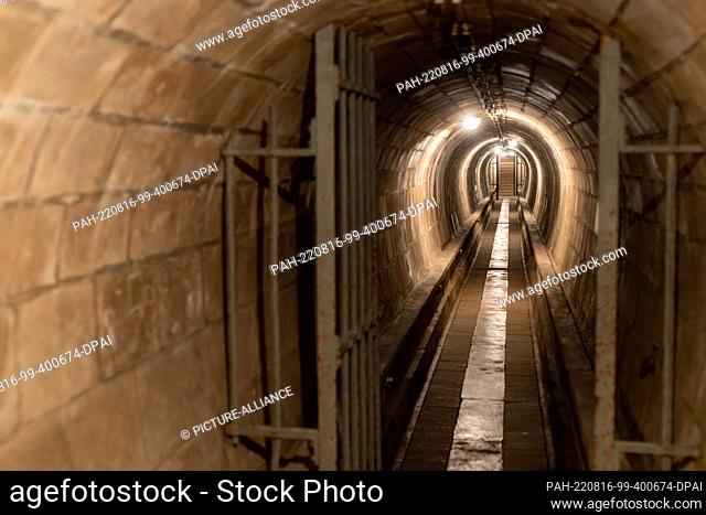 10 August 2022, France, Mutzig: Lamps illuminate an oval corridor in a bunker. The ""Feste Kaiser Wilhelm II"" complex with underground barracks and corridors