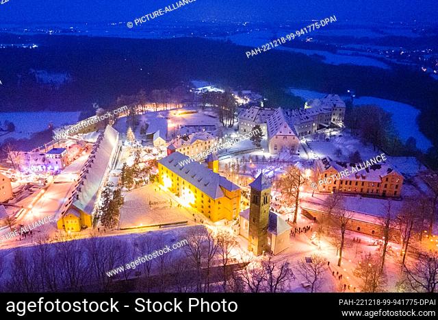 17 December 2022, Saxony, Königstein: Brightly lit are the stalls at the Christmas market on the Königstein Fortress (aerial view with a drone)