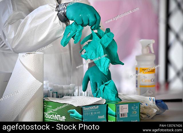 Topic picture Corona PCR test. Rubber gloves, gloves, medical staff wear protective suit and face shield, full face mask, face mask