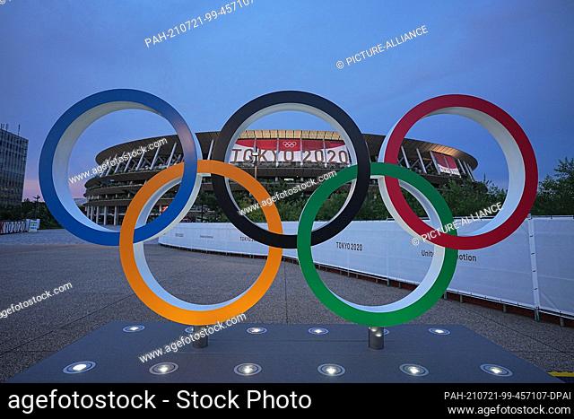 21 July 2021, Japan, Tokio: In the evening twilight Olympic rings stand in front of the Olympic Stadium. The Olympic Stadium is the sports venue of the opening...