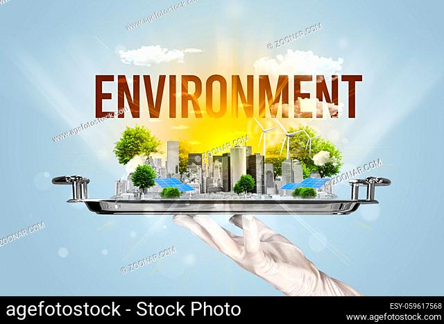 Waiter serving eco city with ENVIRONMENT inscription, renewabke energy concept