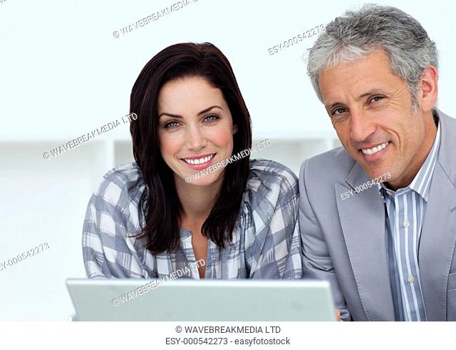 Cheerful business people working at a computer in an office
