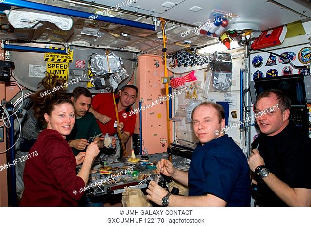 Expedition 23 crew members share a meal in the Unity node of the International Space Station. Pictured from the right are NASA astronaut T.J