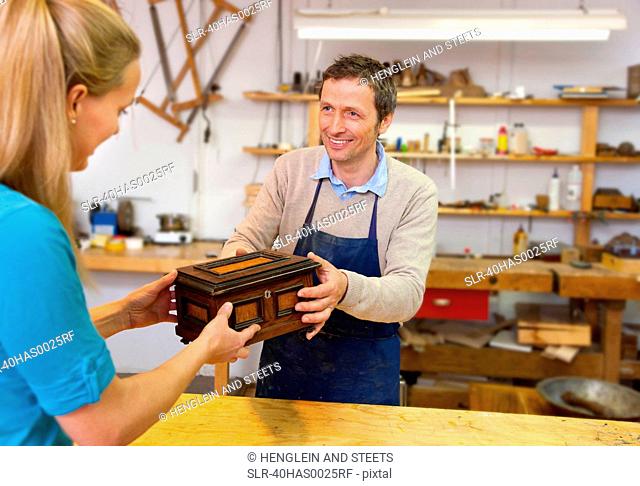Carpenter giving jewelry box to client