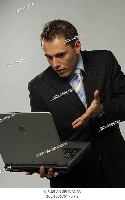 Businessman looking at his laptop in disbelief