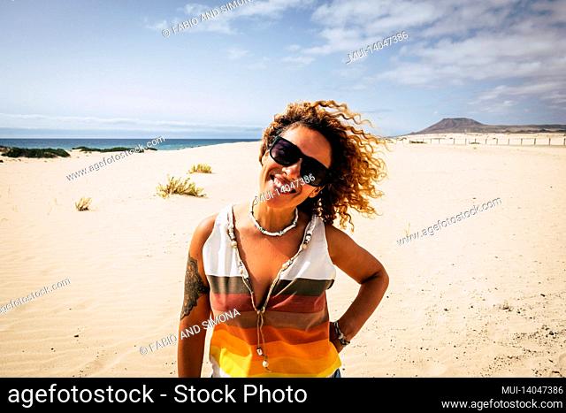portrait of real adult pretty woman smiling and enjoying the beach in tropical paradise with ocean and blue sky in background - concept of travel people and...