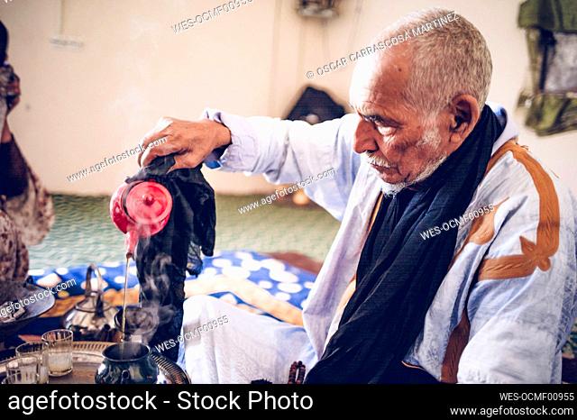 Senior man in Smara refugee camp preparing tea, Tindouf, Algeria