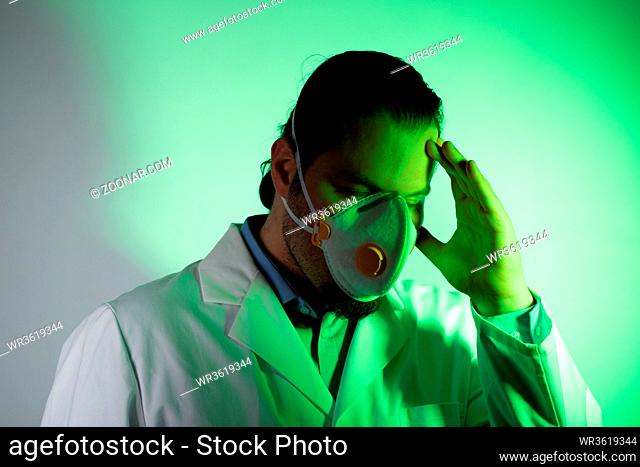 Medical doctor wearing a respiratory mask. Green light emergency and medicine crisis concept