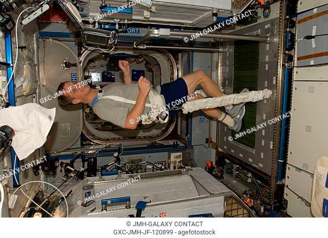 NASA astronaut T.J. Creamer, Expedition 22 flight engineer, equipped with a bungee harness, exercises on the Combined Operational Load Bearing External...