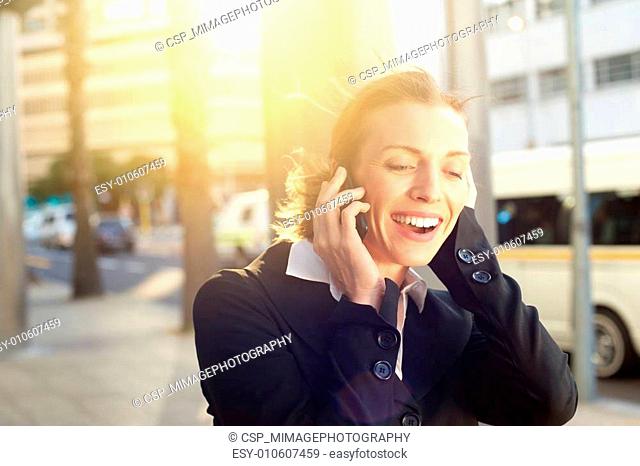 Beautiful business woman smiling on mobile phone outdoors