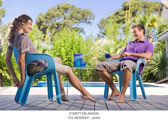 Couple on a wooden terrace by a pool