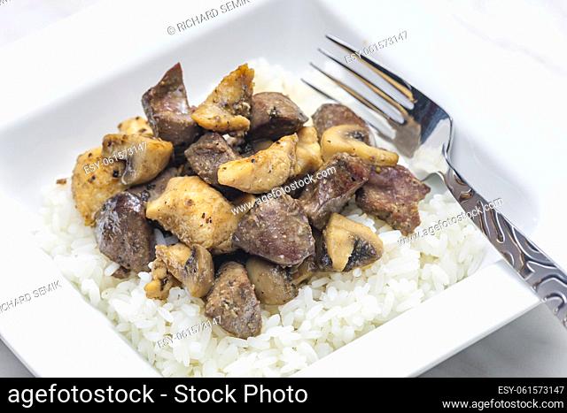 mixture of fried livers, poultry meat and champignons served with rice