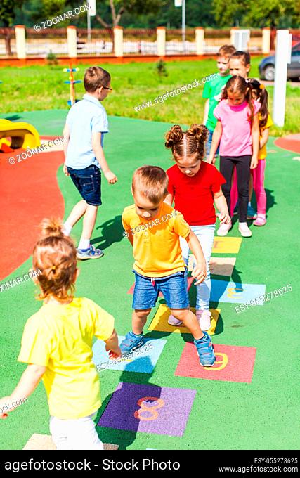 The kids jumping one by one playing hopscotch on a new playground