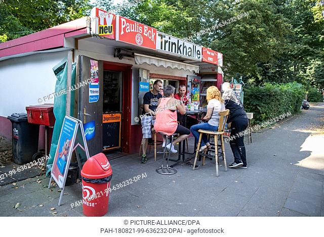 02 August 2018, Germany, Essen: Kiosk owner Thomas Paul (L) sits with customers in front of his pump room. In addition to more classic drinking halls in the...