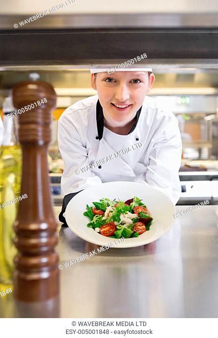Chef happily presenting salad in kitchen