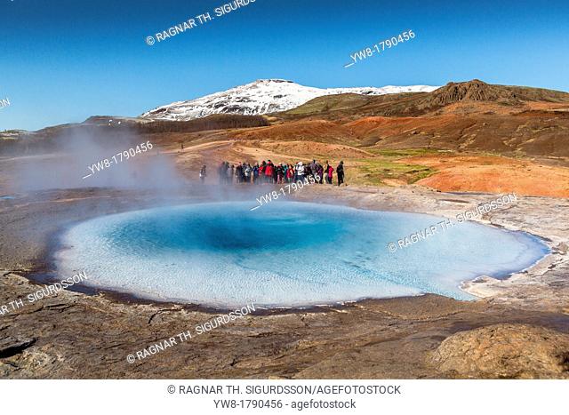 Tourist waiting for Strokkur geyser to erupt, Iceland Strokkur is a fountain geyser in the geothermal area beside the Hvita River  It is one of Iceland's most...
