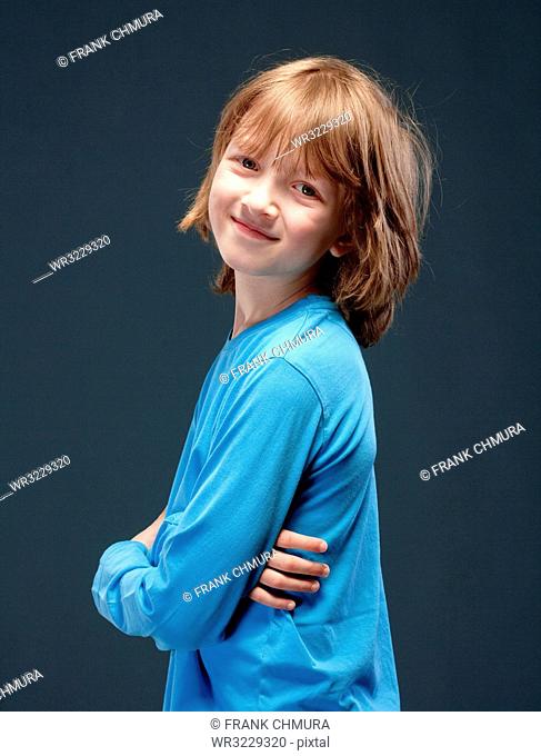 Portrait of a Boy with Long Blond Hair in Blue Top