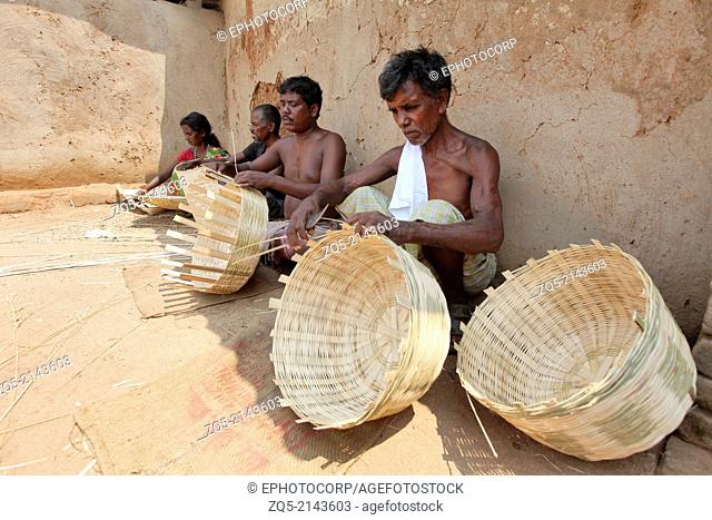 Tribal artisans making baskets with dry bamboo strips. Uraov tribe. Baludih village, Bokaro district, Jharkhand, India