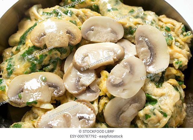 Omelette with mushrooms in frying pan close-up