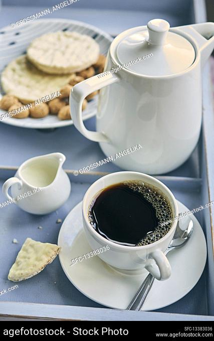 A cup of filter coffee with biscuits and pastries