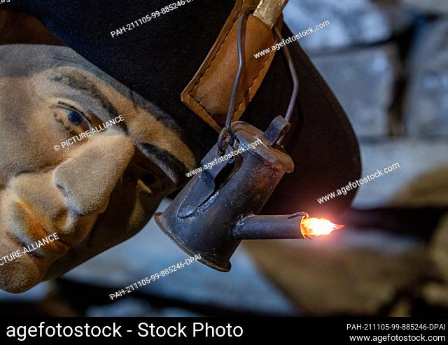 05 November 2021, Saxony-Anhalt, Wettelrode: A miner with a miner's lamp, as he also worked in the old mining industry in Mansfeld