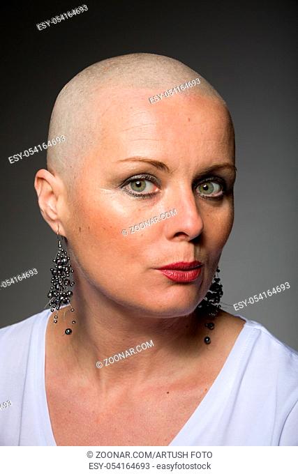 Portrait of beautiful middle age woman sad patient with cancer with shaved head without hair, hope in healing