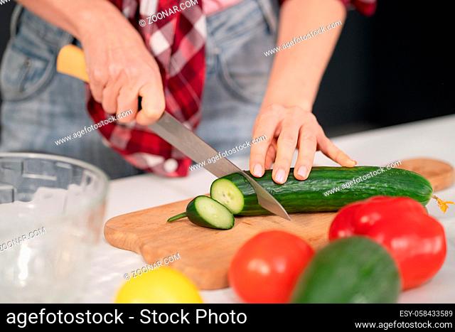 Close up. Young woman cutting ingredients on table cooking a lunch or dinner standing in the kitchen. Healthy food living. Healthy lifestyle