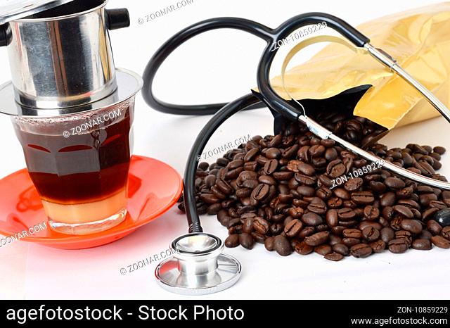stethoscope with coffee beans on white background