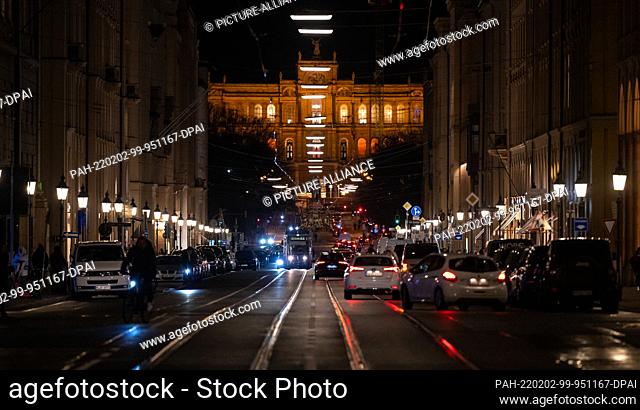 02 February 2022, Bavaria, Munich: Cars drive along Maximilianstrasse. In the background you can see the Maximilianeum, seat of the Bavarian Parliament