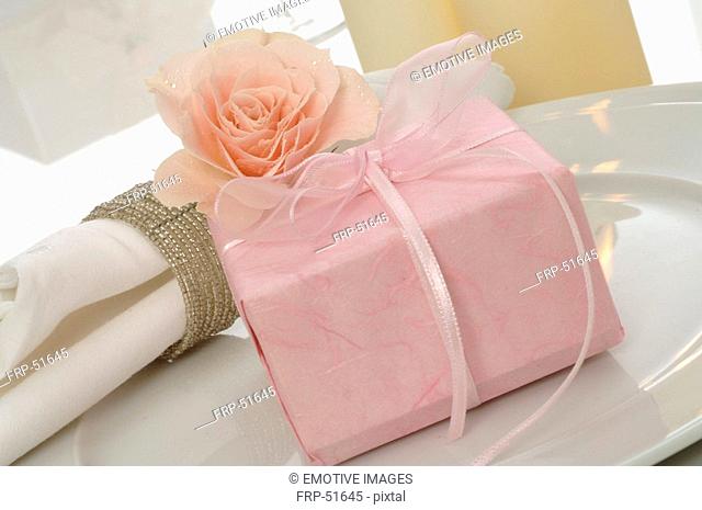 Table decoration with pink rose and present
