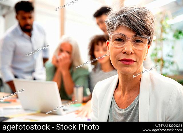Female agency manager looking at the camera during meeting