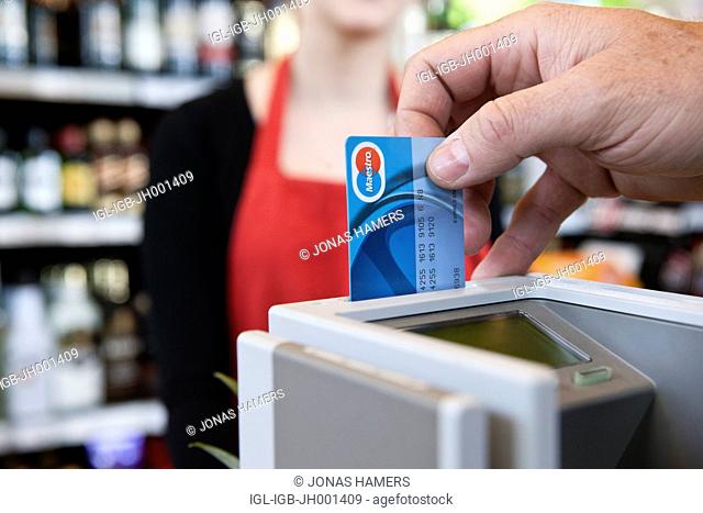 ATM machine and a Maestro credit card during a payment in a supermarket