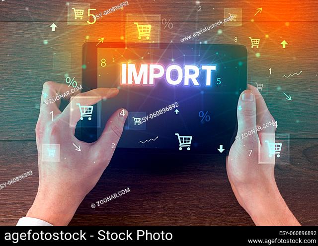 Close-up of a hand holding tablet with IMPORT inscription, online shopping concept