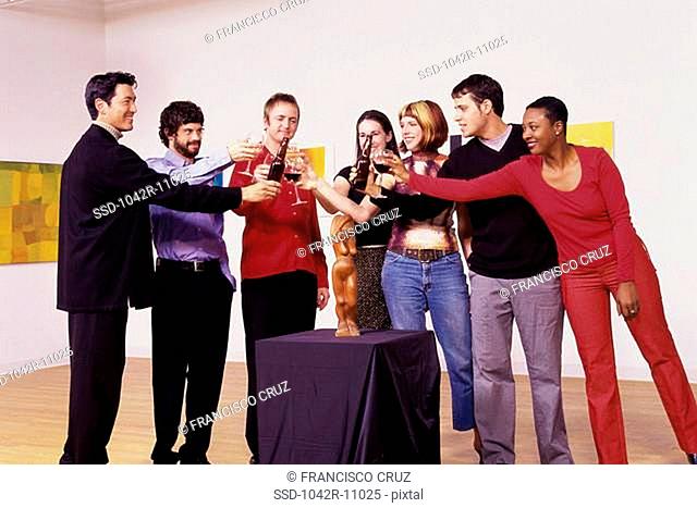 Group of people toasting in an art gallery